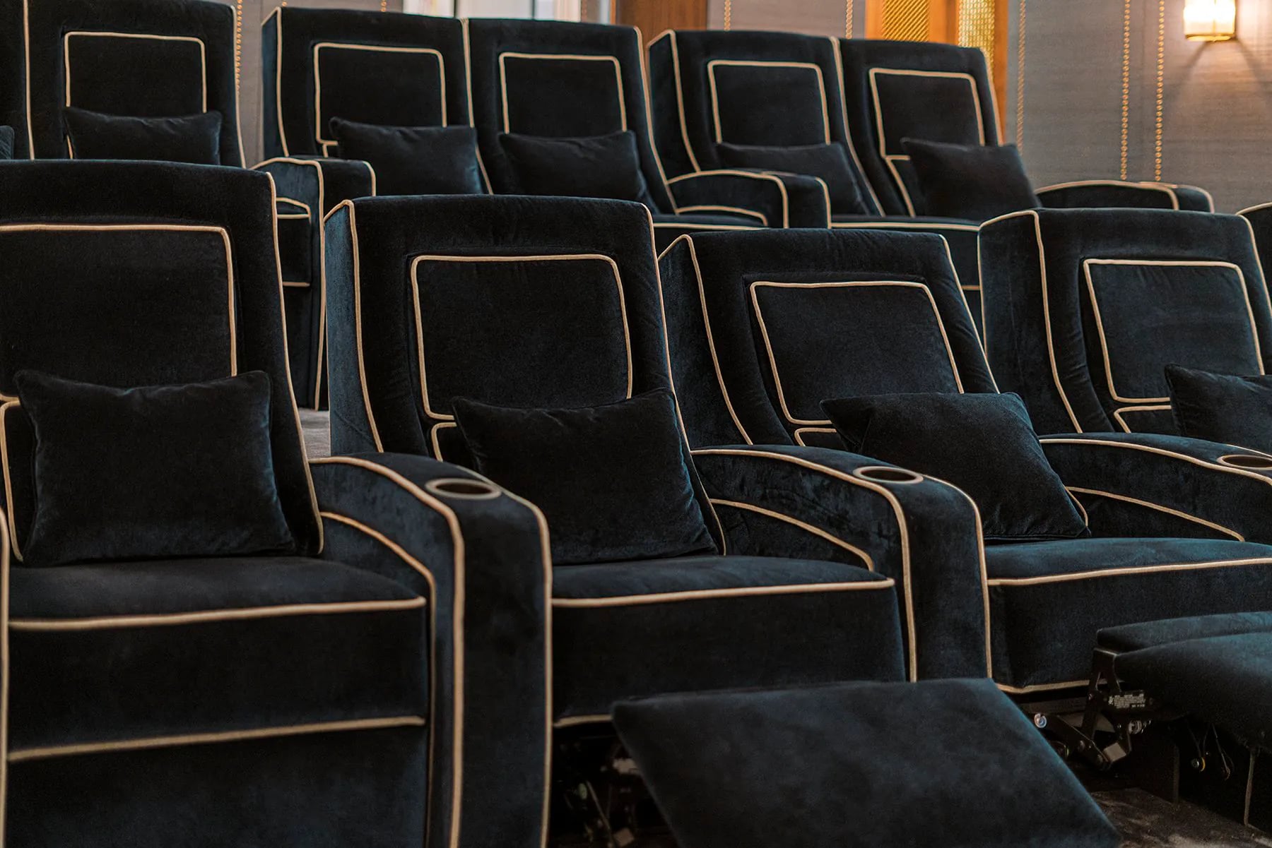 Salle cinéma privée avec panneaux acoustiques, assises lounge et lumière indirecte